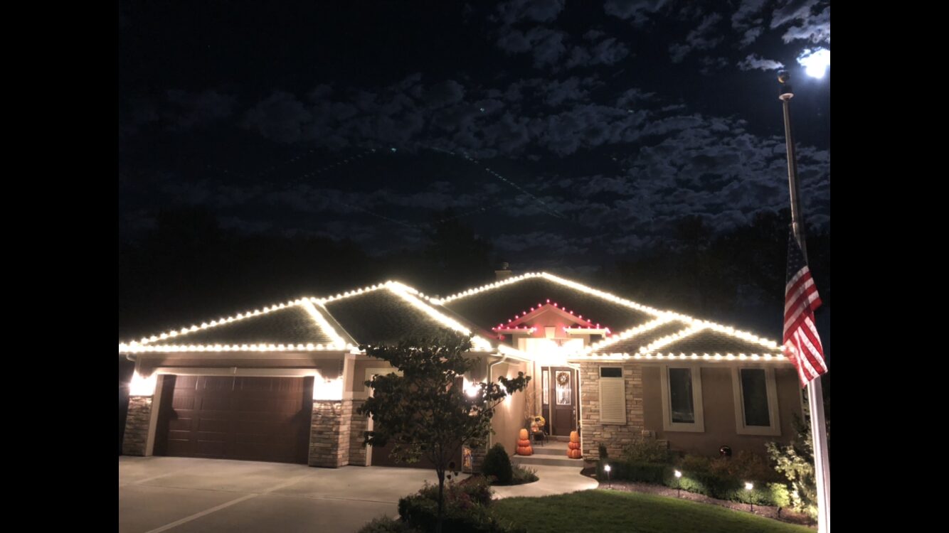 Warm white roofline with red accent section under moonlight